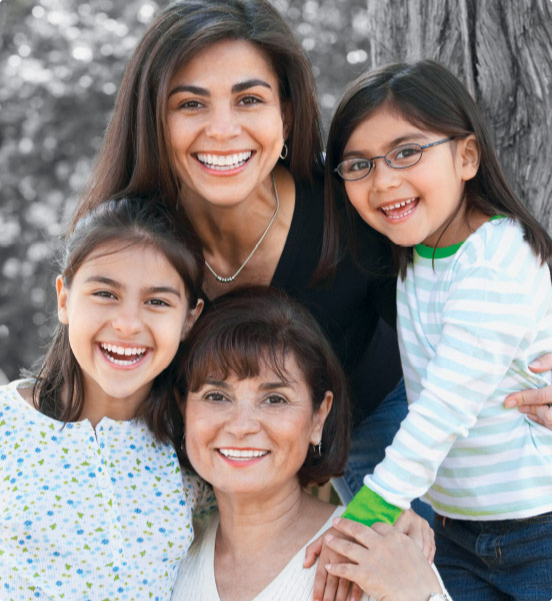 Hispanic family poses for a photo under a tree